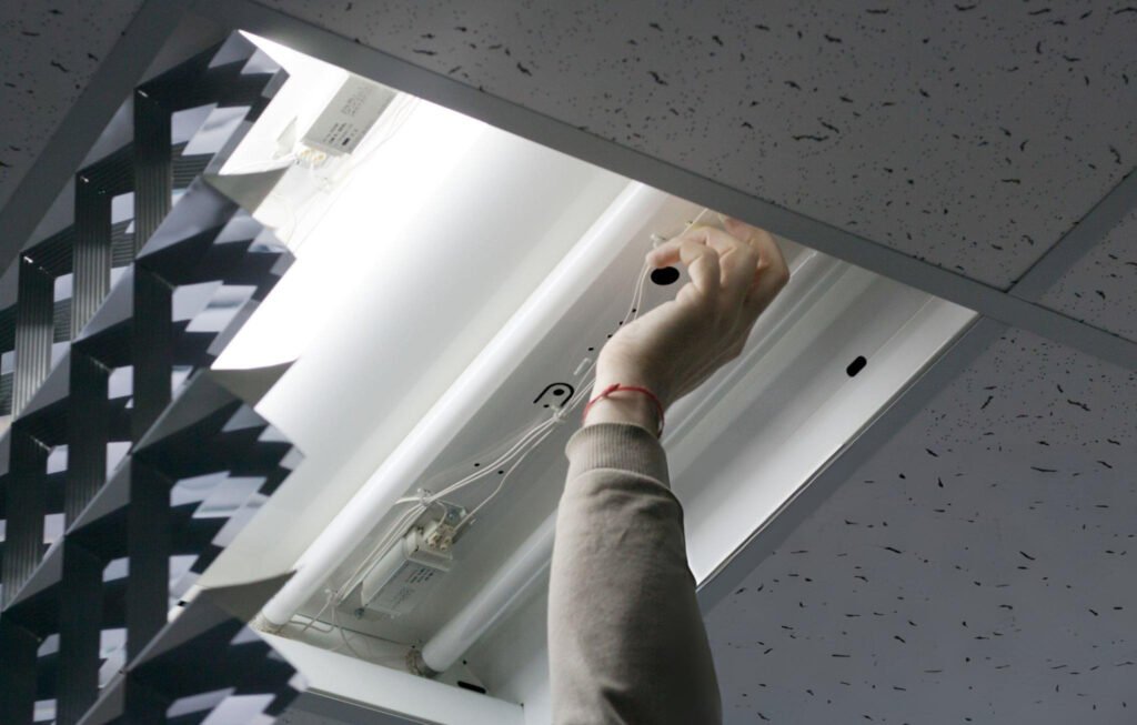 handyman fixing a light